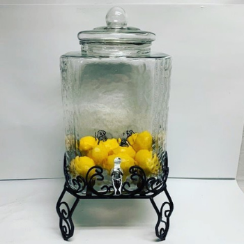 A 4.75-gallon glass beverage dispenser with a sturdy iron base, ideal for serving refreshing drinks at events.